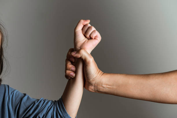 A man grasps onto a child’s forearm while the child makes a fist.